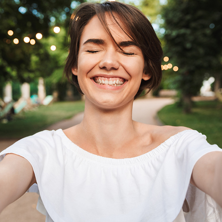 Cheerful Young Girl With Eyes Closeed Taking A Selfie